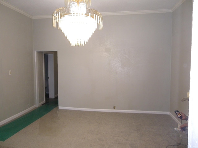 spare room with carpet flooring, ornamental molding, and a notable chandelier