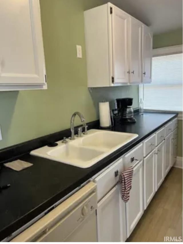 kitchen with sink, light hardwood / wood-style flooring, dishwasher, and white cabinets