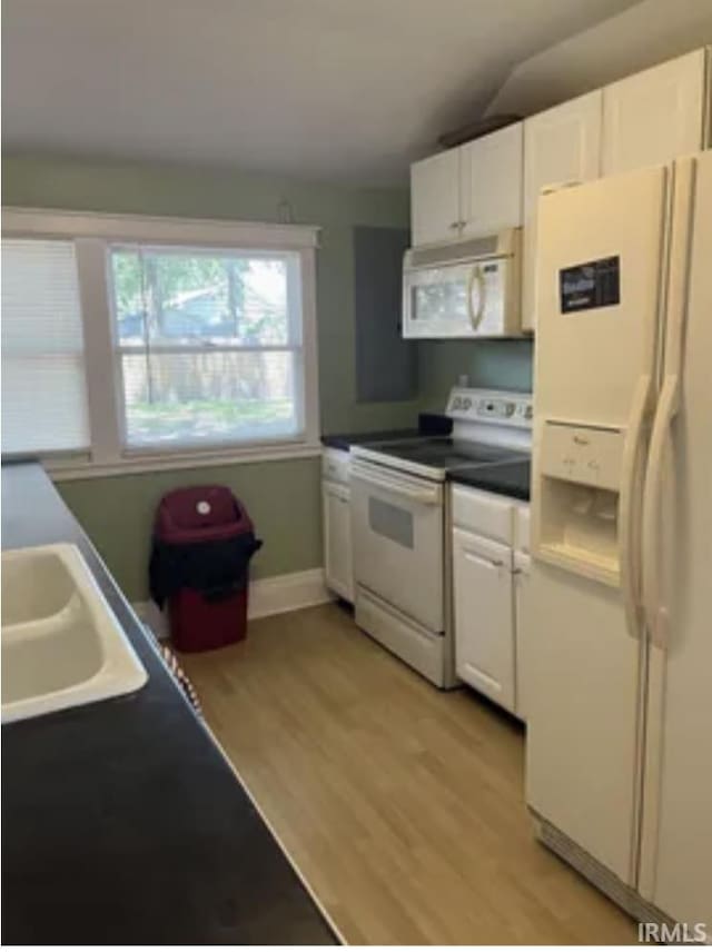 kitchen with white appliances, light hardwood / wood-style floors, sink, and white cabinets