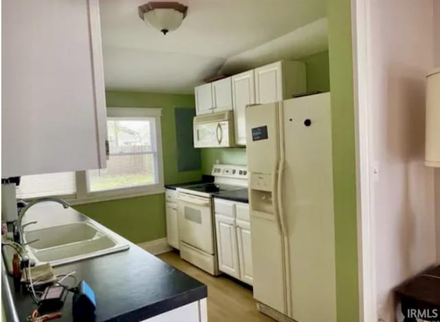 kitchen featuring sink, white cabinets, white appliances, and light wood-type flooring