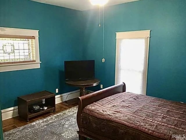 bedroom with a baseboard heating unit and hardwood / wood-style flooring