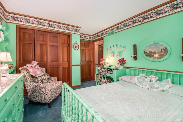 bedroom with dark colored carpet, ornamental molding, and a closet