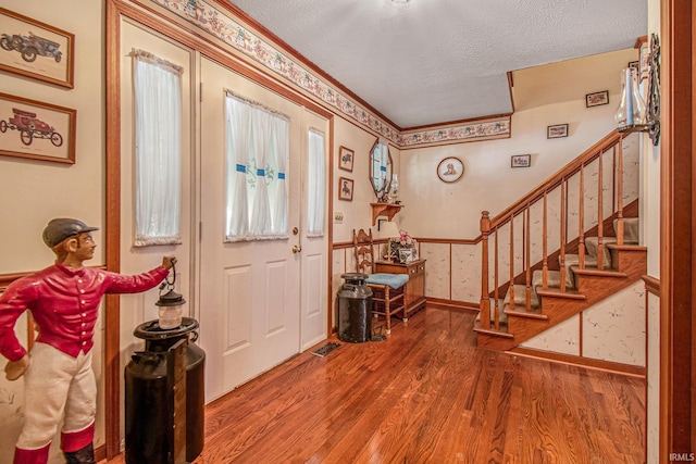 foyer entrance featuring hardwood / wood-style flooring and a textured ceiling