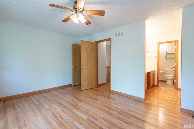 unfurnished bedroom with a textured ceiling and light hardwood / wood-style flooring