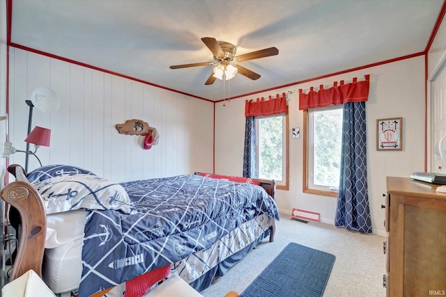 carpeted bedroom featuring crown molding and ceiling fan