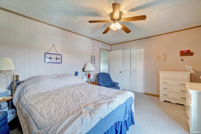 bedroom featuring ornamental molding, light carpet, ceiling fan, and a closet