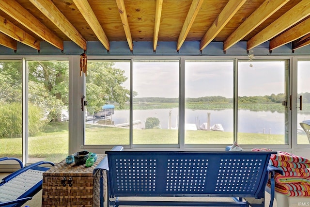 sunroom featuring a water view