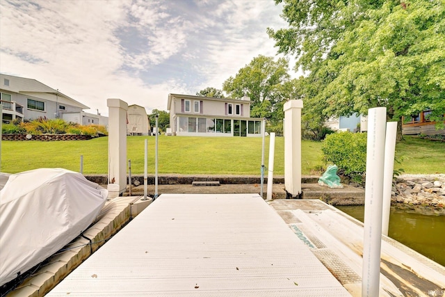 dock area with a water view and a lawn