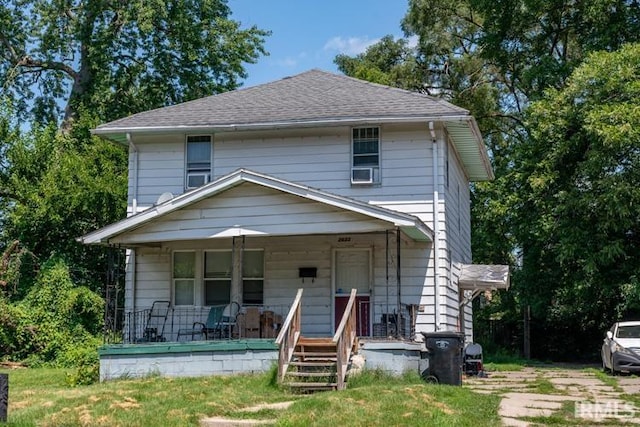 traditional style home featuring a porch and a shingled roof