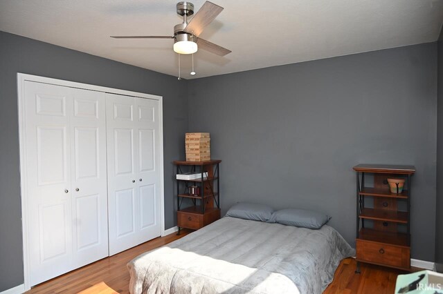 bedroom featuring ceiling fan, hardwood / wood-style flooring, and a closet