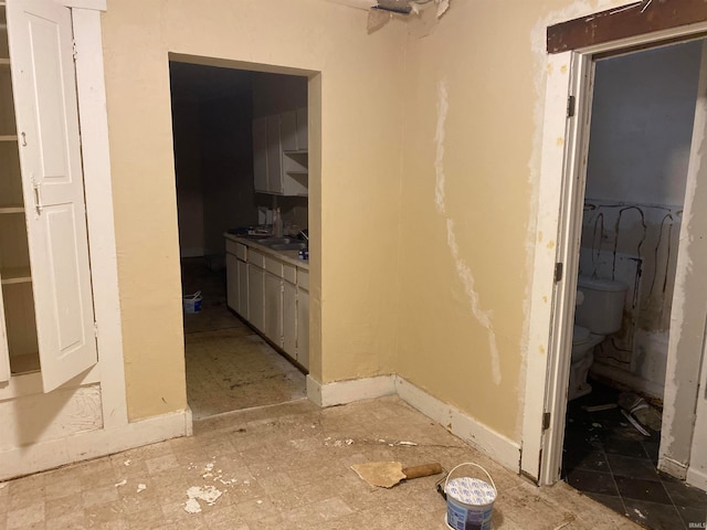 hallway with sink and tile patterned flooring