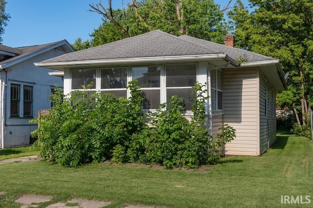 view of home's exterior featuring a yard and a sunroom