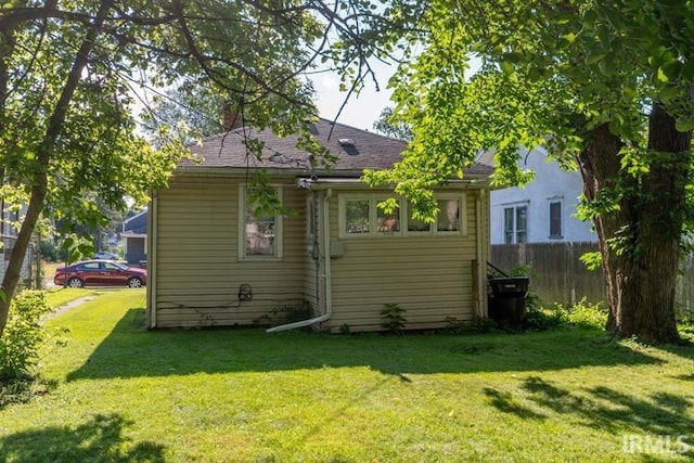 rear view of house featuring a lawn