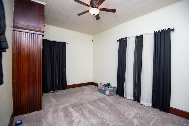 carpeted spare room featuring ceiling fan