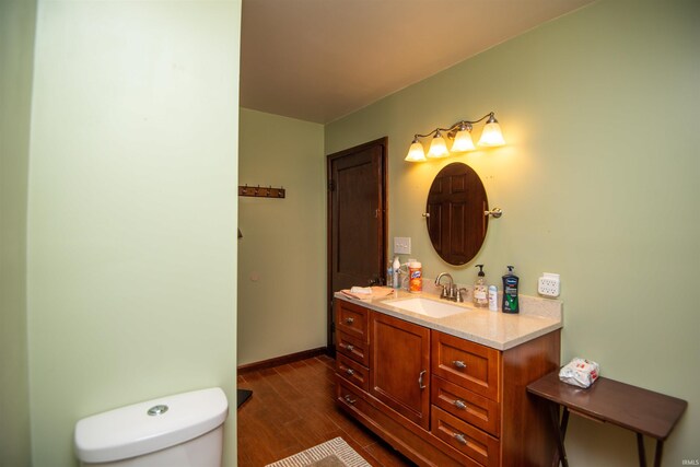 bathroom featuring wood-type flooring, toilet, and vanity