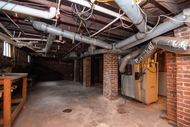 basement featuring brick wall and heating unit