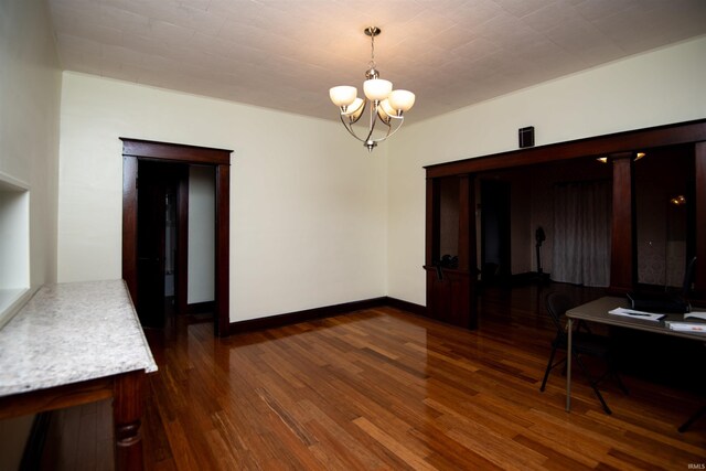 dining area with hardwood / wood-style floors and an inviting chandelier