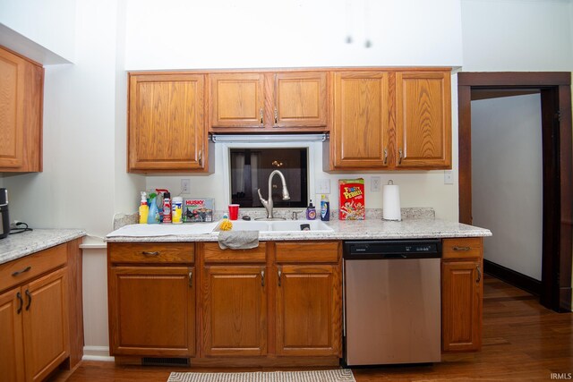 kitchen featuring dark hardwood / wood-style flooring, stainless steel dishwasher, sink, and light stone counters