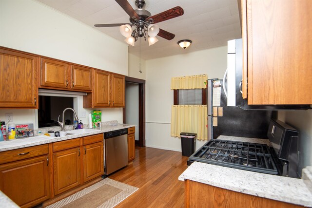 kitchen featuring ceiling fan, gas range oven, light hardwood / wood-style floors, dishwasher, and sink