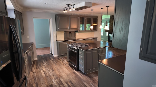 kitchen featuring rail lighting, a textured ceiling, a center island, backsplash, and black appliances