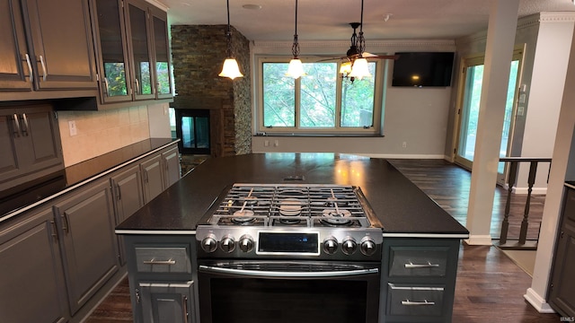 kitchen featuring double oven range, a kitchen island, decorative backsplash, dark wood-type flooring, and ceiling fan