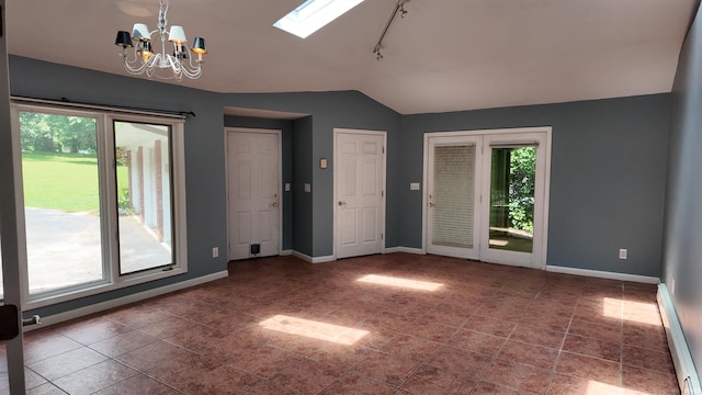 interior space with tile patterned flooring, rail lighting, a chandelier, a baseboard heating unit, and vaulted ceiling with skylight