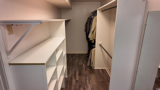 walk in closet with dark hardwood / wood-style flooring