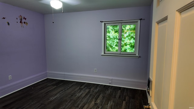 empty room with dark wood-type flooring and ceiling fan