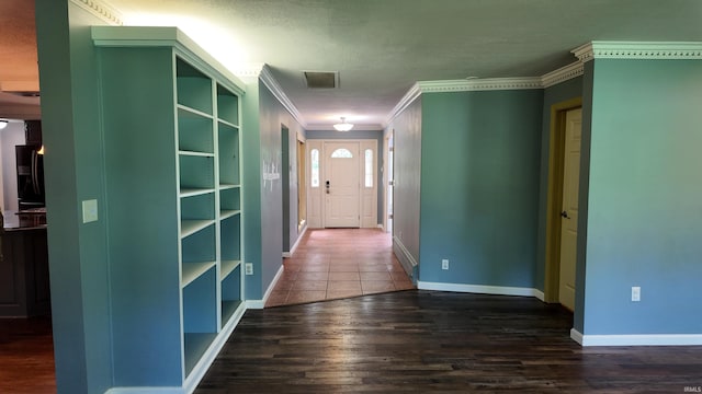 hall with hardwood / wood-style flooring, a textured ceiling, and ornamental molding