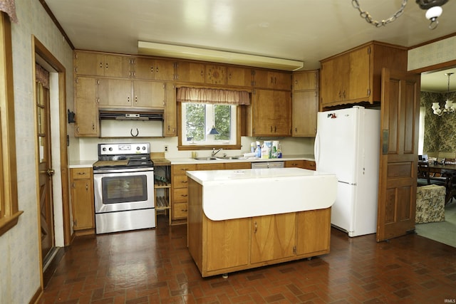 kitchen featuring an inviting chandelier, stainless steel electric range, brick floor, and freestanding refrigerator