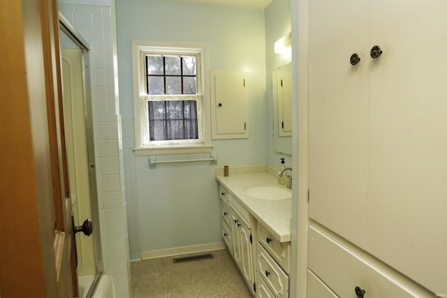 full bath featuring shower / bath combination with glass door, vanity, visible vents, baseboards, and tile patterned floors