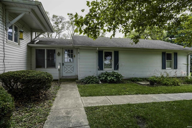 view of front of home featuring a shingled roof and a front yard