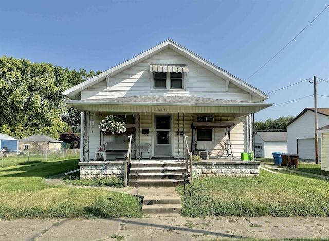 bungalow with a porch and a front lawn