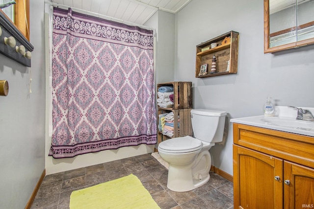 bathroom with baseboards, shower / bath combo with shower curtain, toilet, stone finish floor, and vanity