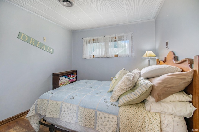 bedroom featuring crown molding, baseboards, and wood finished floors