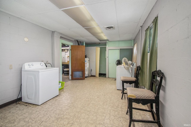 finished basement featuring washer / dryer, concrete block wall, visible vents, and tile patterned floors