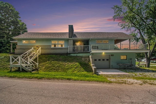 view of front of house with brick siding, a balcony, driveway, and a garage