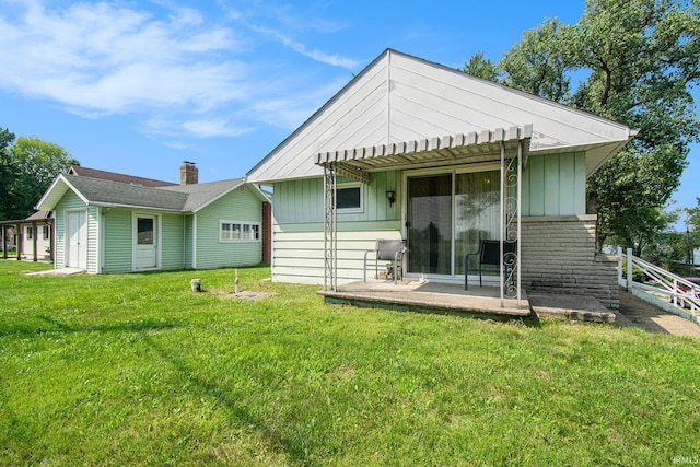 rear view of property featuring a yard and board and batten siding