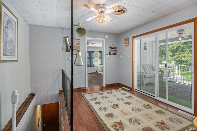 doorway to outside with baseboards, wood finished floors, and ceiling fan