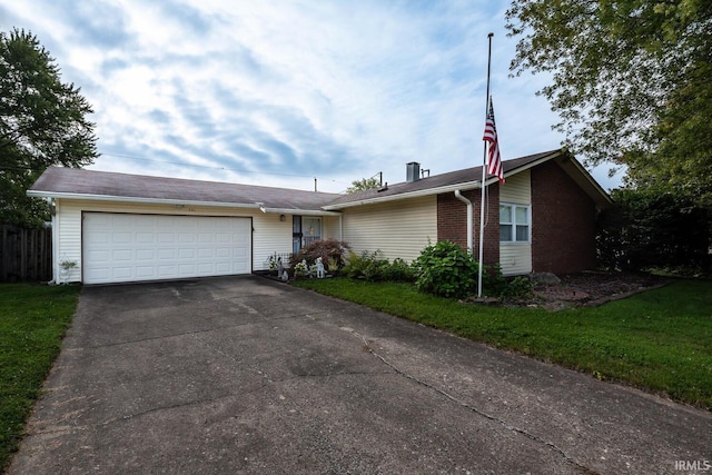 ranch-style home with a garage and a front lawn