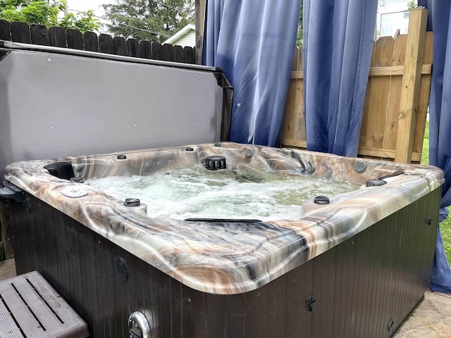 exterior space featuring tile patterned floors and a hot tub