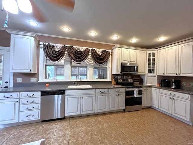 kitchen featuring light tile patterned floors, appliances with stainless steel finishes, sink, and ceiling fan