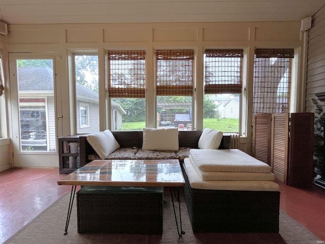 living room featuring a wealth of natural light and concrete floors