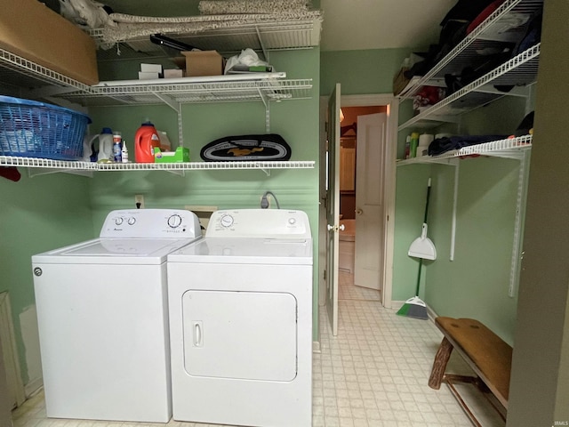 laundry room featuring washing machine and dryer and light tile patterned floors