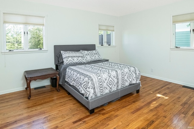 bedroom featuring multiple windows and hardwood / wood-style floors