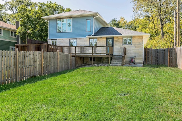 back of property with a wooden deck and a lawn