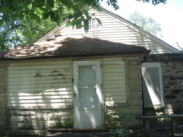 view of side of property featuring roof with shingles