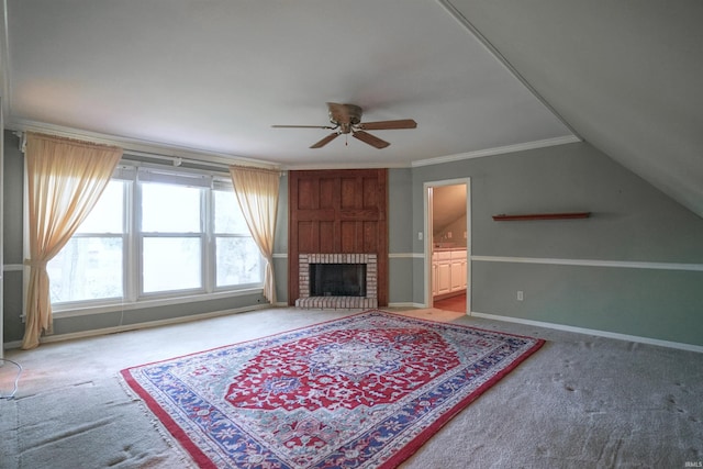 carpeted living room featuring vaulted ceiling, ceiling fan, a fireplace, and crown molding