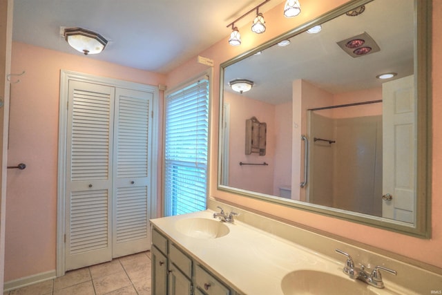 bathroom with tile patterned flooring, a shower, and vanity