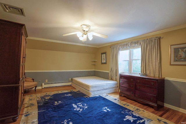 bedroom featuring wood-type flooring, ornamental molding, ceiling fan, and a baseboard heating unit